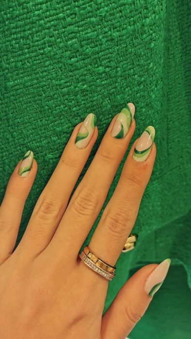 Chica con las uñas pintadas en verde con tono nude 