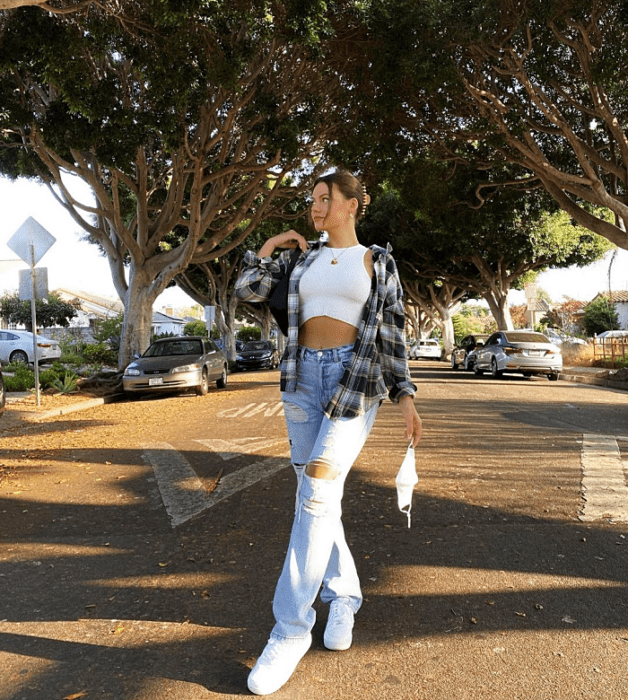 chica de cabello largo usando un crop top blanco, negro,. beige, café, verde, azul de manga larga, corta, con jeans ajustados, pantalones negros de cuero, bolso pequeño de mano