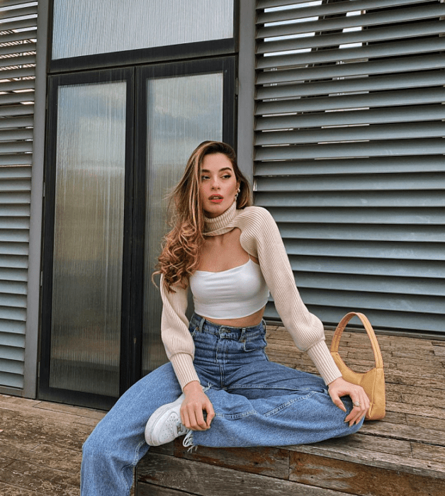 chica de cabello largo usando un crop top blanco, negro,. beige, café, verde, azul de manga larga, corta, con jeans ajustados, pantalones negros de cuero, bolso pequeño de mano