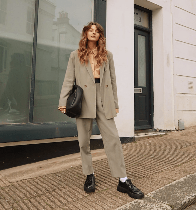 chica de cabello largo usando una camiseta blanca, camisa de vestir, saco, blazer, chaqueta de cuero, beige, negra, verde de rayas, pantalones de vestir, jeans a la cintura, cinturón, zapatos, botas, botines, mocasines, lentes de sol