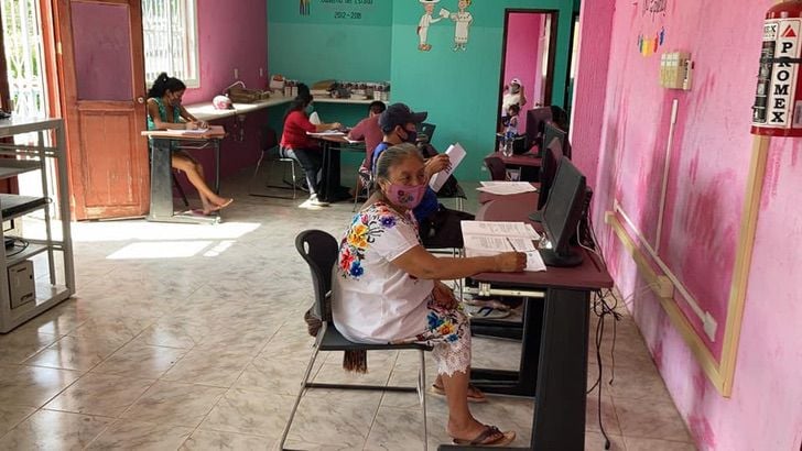 Abuelita sentada frente a un escritorio practicando computación ;¡Nada es imposible! Abuelita de 71 años concluye sus estudios básicos