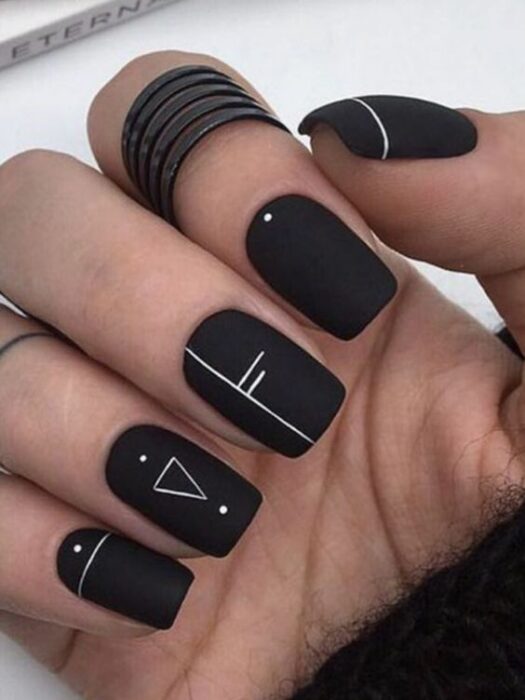 Manicura en tono negro con diseños minimalistas en blanco ;13 Ideas para animarte a llevar una manicura en tono mate 