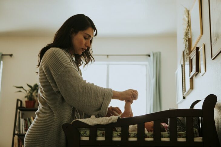 Woman changing her baby's diaper