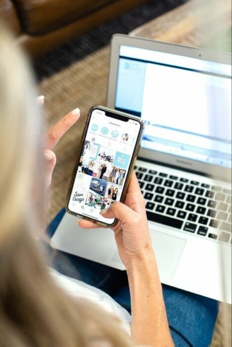 Woman checking her cell phone and computer 