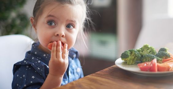 Little girl eating a plate with vegetables 