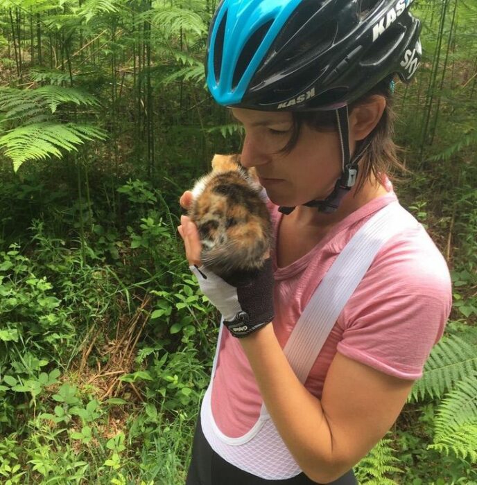 Mujer rescatando a una gatita que estaba perdida en el bosque 