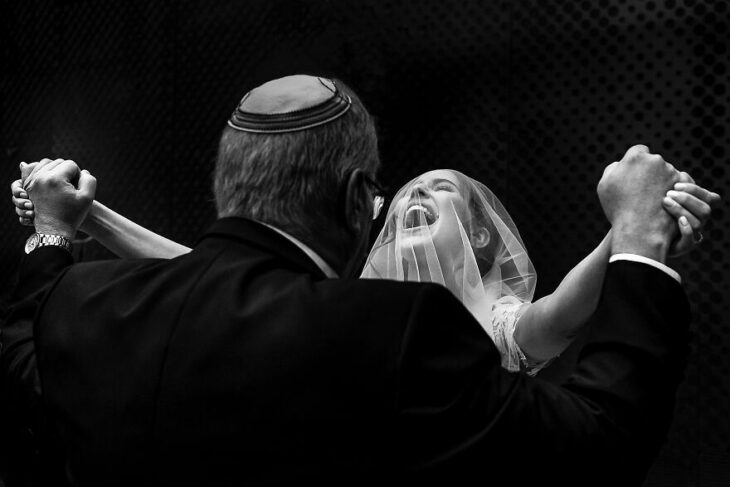 Padre e hija sonriendo el día de la boda mientras se ven por primera vez