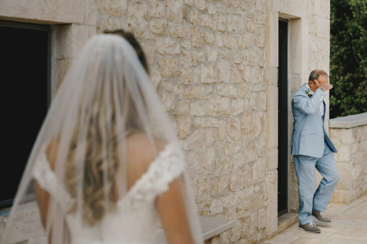 Padre e hija sonriendo el día de la boda mientras se ven por primera vez