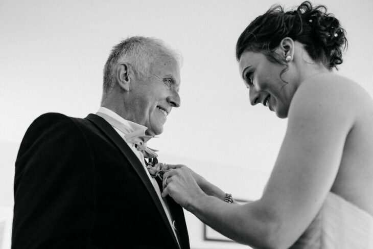 Padre e hija sonriendo el día de la boda mientras se ven por primera vez