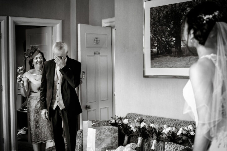 Padre e hija sonriendo el día de la boda mientras se ven por primera vez