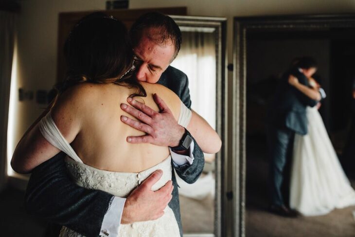 Padre e hija sonriendo el día de la boda mientras se ven por primera vez