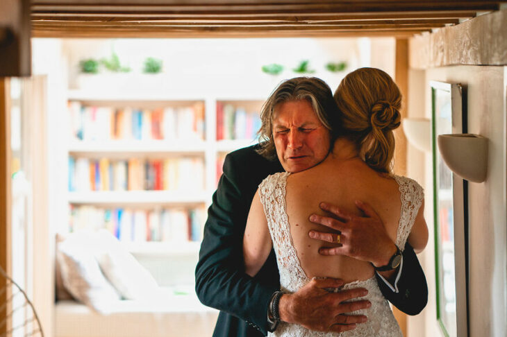 Padre e hija sonriendo el día de la boda mientras se ven por primera vez