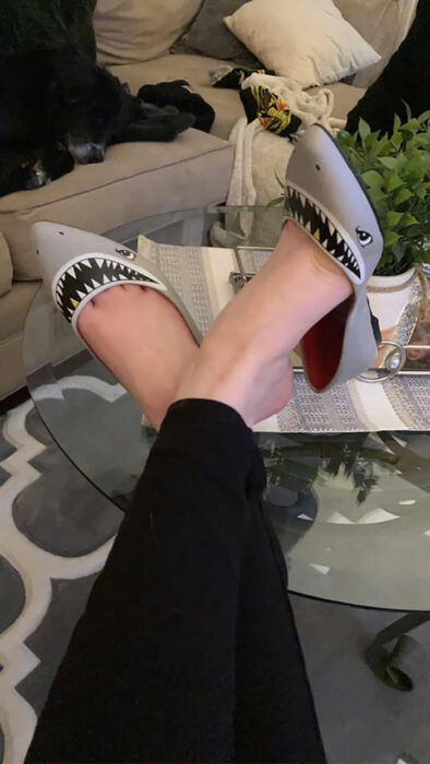 Chica usando unos zapatos de tiburón