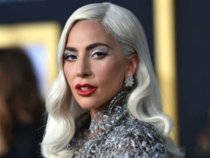 Lady Gaga posando para una fotografía en una alfombra roja 