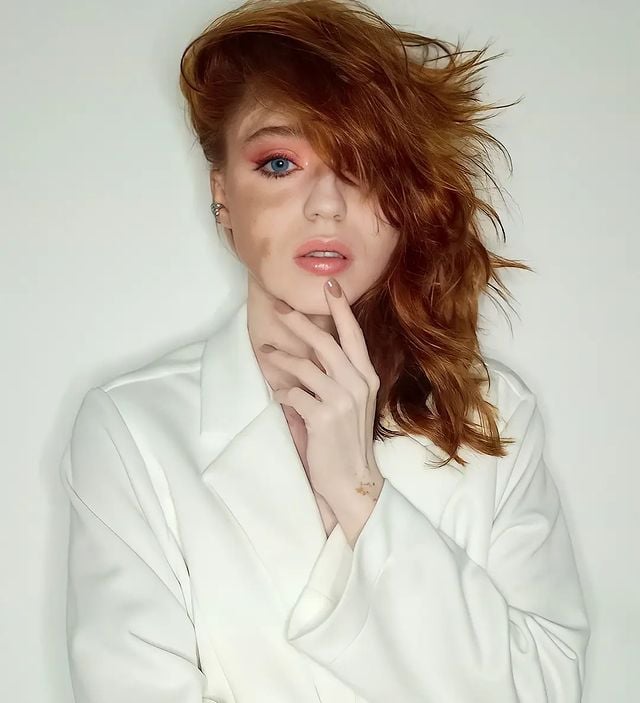 Chica posando con un blazer largo de color blanco