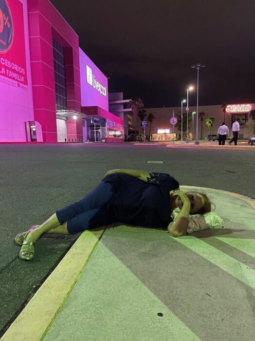 Woman sitting on the sidewalk; Woman lost her parking ticket and refused to pay the fine