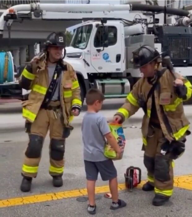 Niño repartiendo dulces a los bomberos en el derrumbe de Miami