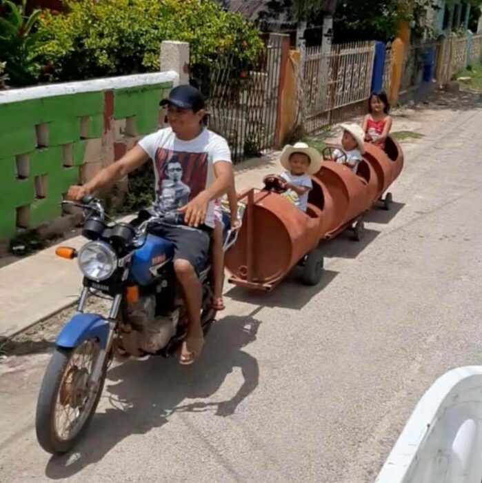 Padre e hijos paseando en un tren de metal ;Papá crea trenecito con botes de metal para sus hijos