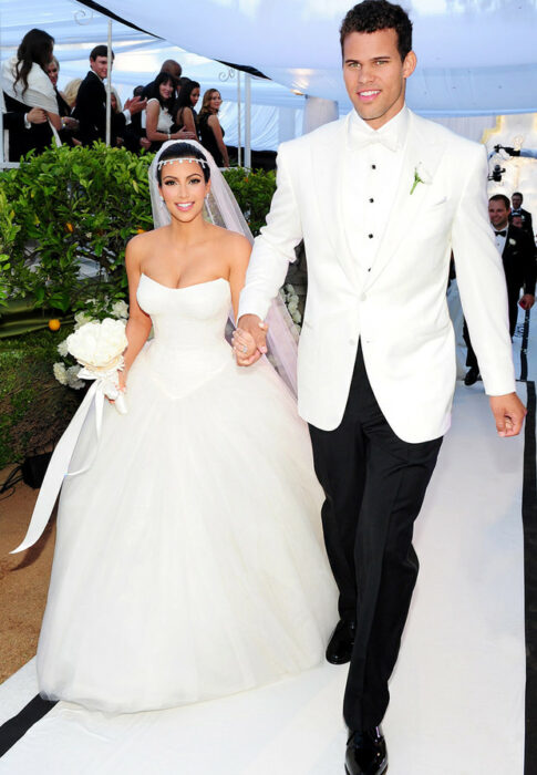 Kris Humphries and Kim Kardashian holding hands on their wedding day 