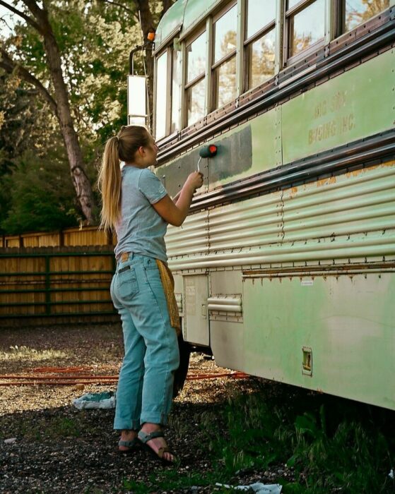 chica pintando un camión; Renuevan un camión y viajan juntas por el mundo después de ser engañadas por el mismo chico