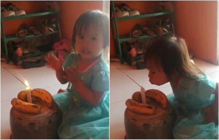 Girl blowing out a candle;  Their parents didn't have for the cake;  was the happiest blowing the candle to three bananas