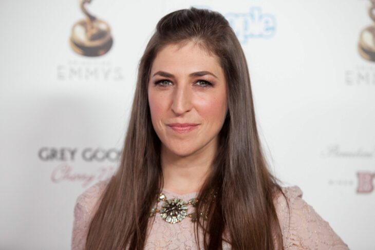 Mayim Bialik posing for a photo on a red carpet 