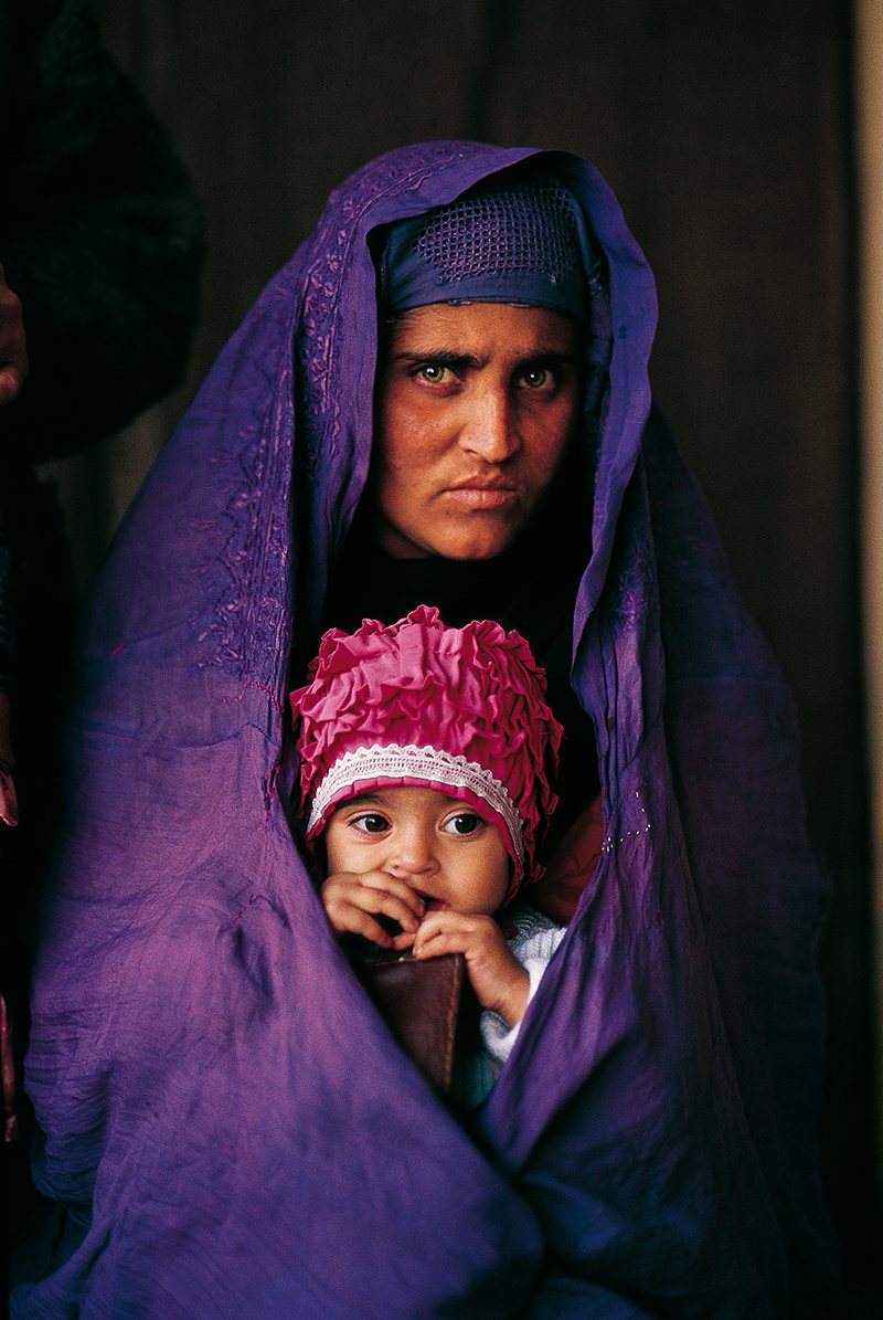 Mujer cargando a una niña; La niña de National Geographic que refleja los cambios en Afganistán. Una vida bajo las sombras