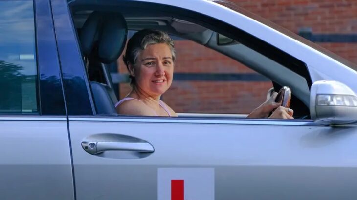 Woman driving a gray car 