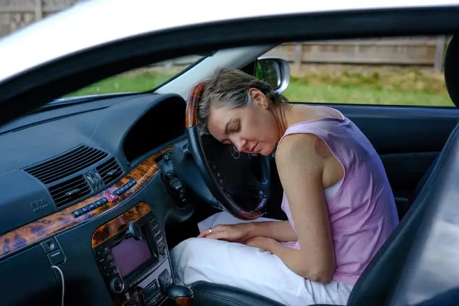 Mujer durmiendo en un coche mientras está estacionada 