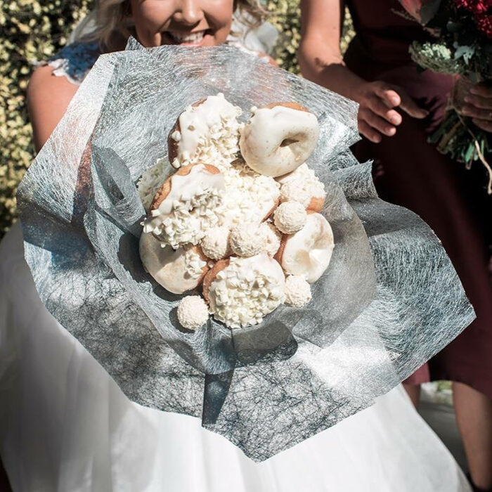 Mujer usando un ramo de novia hecho de donas 