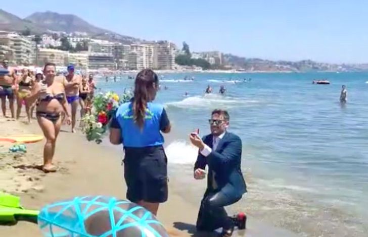 Hombre con la rodilla en la playa proponiendo matrimonio 