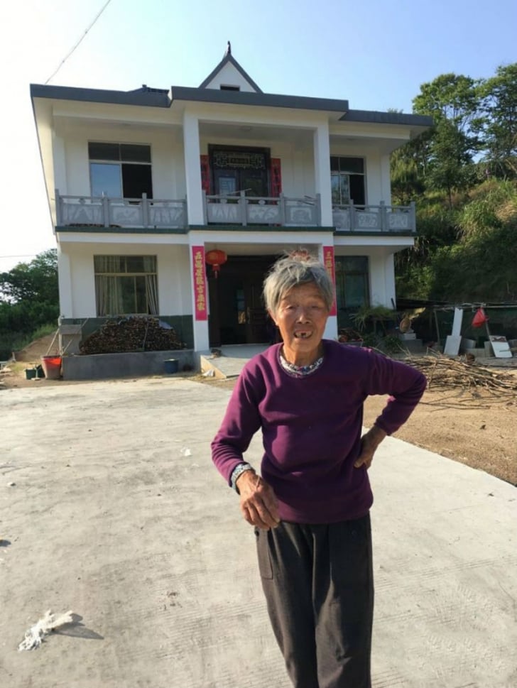 Mujer frente a una casa; Adoptó a bebé abandonada y 25 años después, ella le agradece con una casa