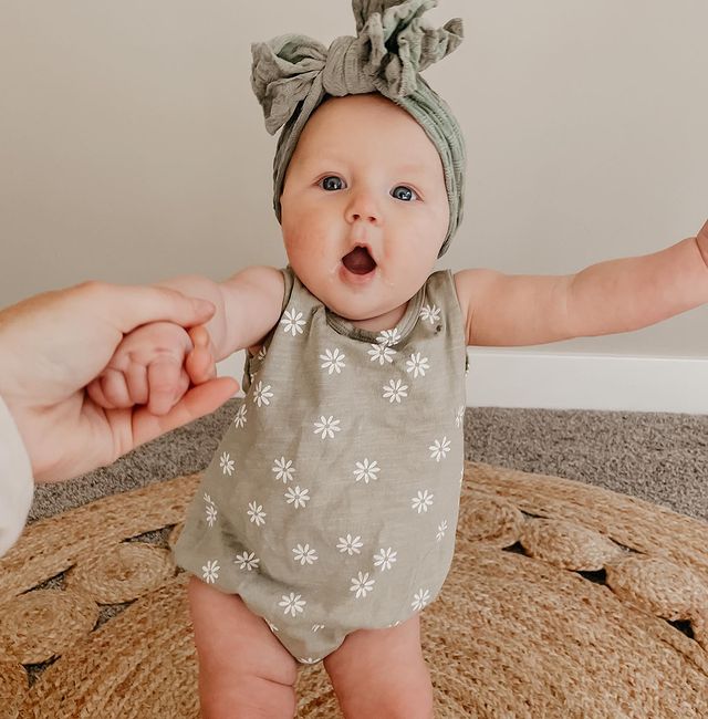 Bebé de cuatro meses sonriendo mientras está sentada 