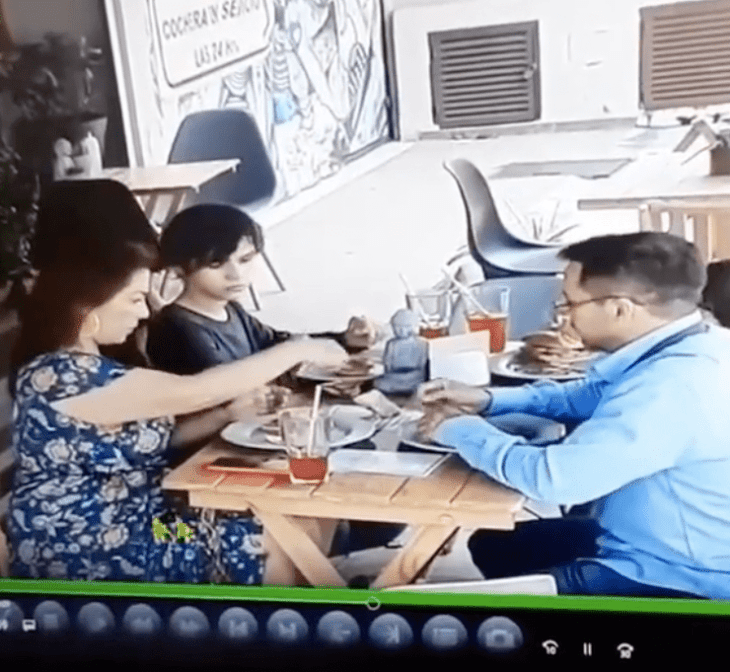 Familia poniendo cabellos en la comida de un restaurante 