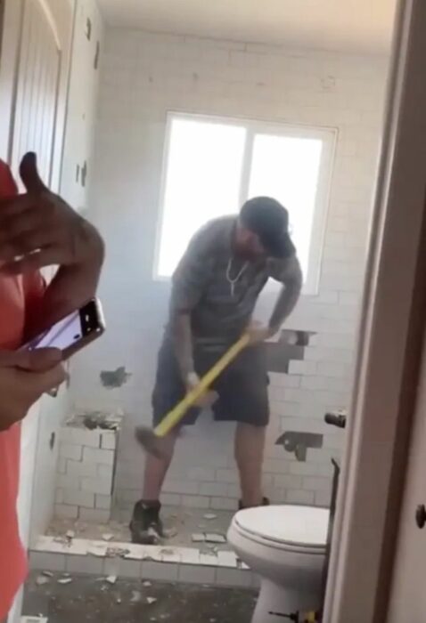 Hombre destruyendo un baño que no le pagaron 
