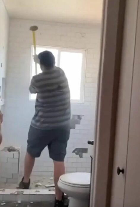 Hombre destruyendo un baño que no le pagaron 