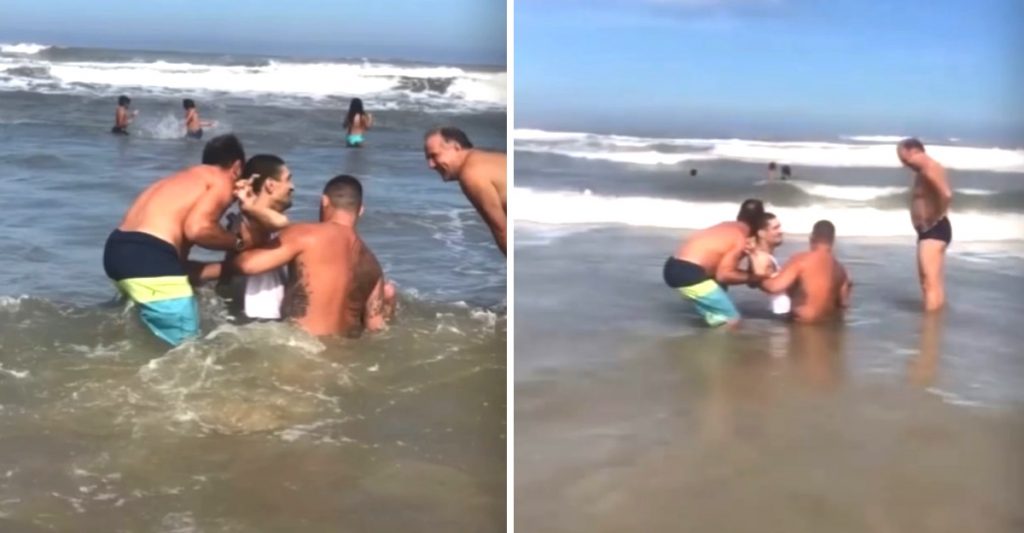 Hombres dentro del mar; Hombres ayudaron a un papá para que su hijo con discapacidad se bañara en el mar