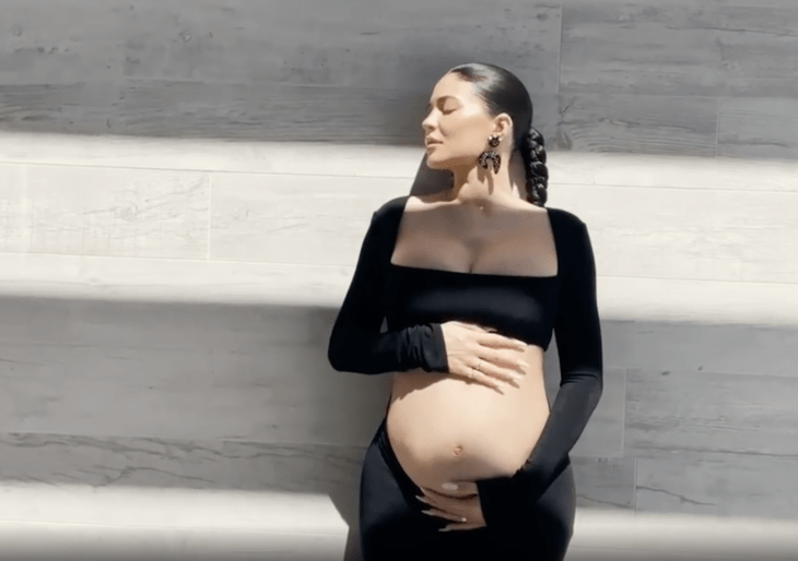 Kylie Jenner posando con un atuendo negro mientras muestra su pancita de embarazo 