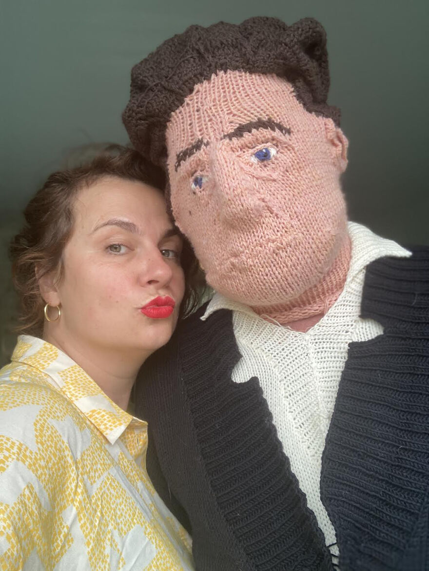 Woman posing next to a knitted doll;  Woman weaves her husband and son in life size