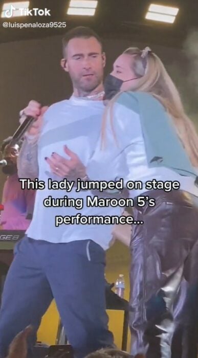 Adam Levine asustado y sacudiéndose a una fan en el escenario