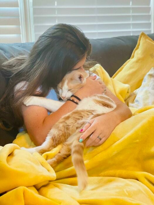 chica cargando un gato ;19 Mascotas rescatadas que te alegrarán el día