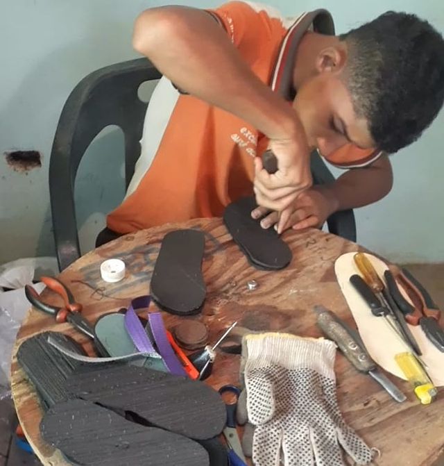 Chico haciendo chancletas con llanta