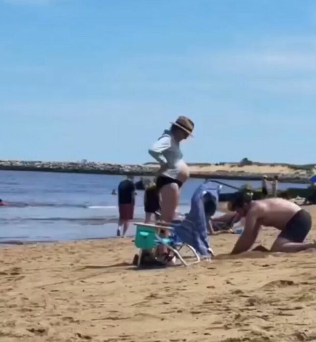 Hombre cavando un hoyo en la playa para que su esposa se recostara 