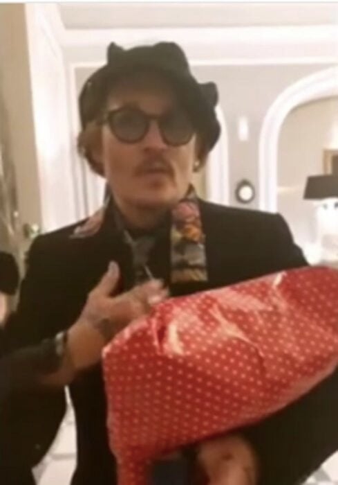 Johnny Depp sosteniendo regalos de sus fans 