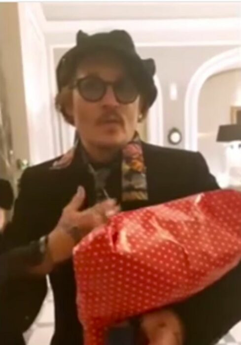 Johnny Depp sosteniendo regalos de sus fans 