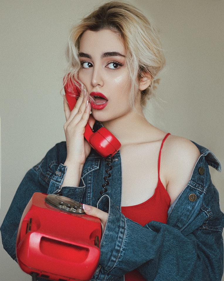 girl with red phone;  Millennials can't talk on the phone