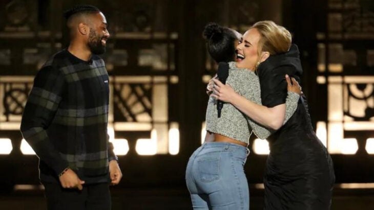 Adele abrazando a una pareja que se comprometió en su concierto