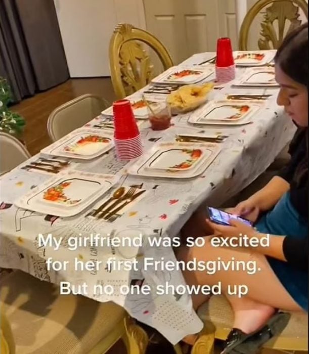 Chica sentada en la mesa esperando la cena de Acción de Gracias 