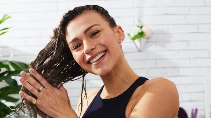 Chica aplicando acondicionador en su cabello 