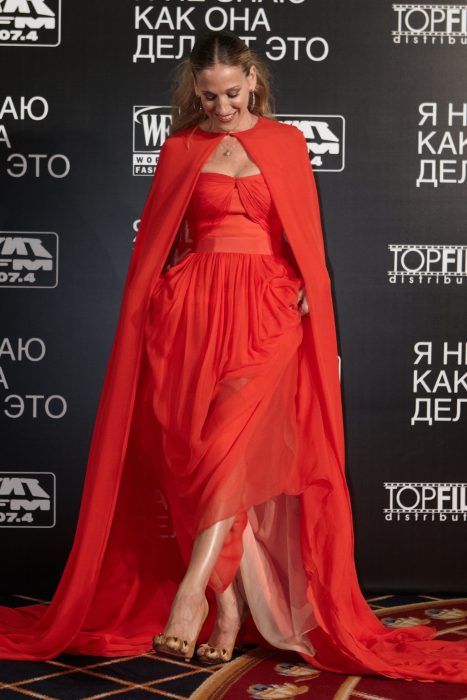 Sarah Jessica Parker posando en la entrega de unos premios posando con un vestido rojo y zapatillas en forma de patas de león 